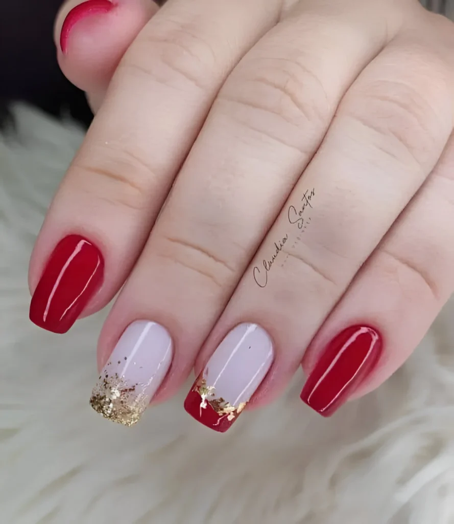 Glossy red nails with nude and gold foil accents for a sophisticated look.