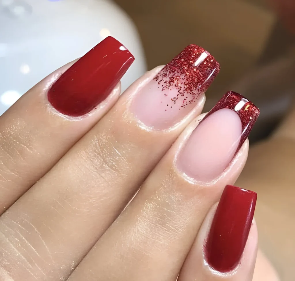 Red ombre nails with glitter tips.