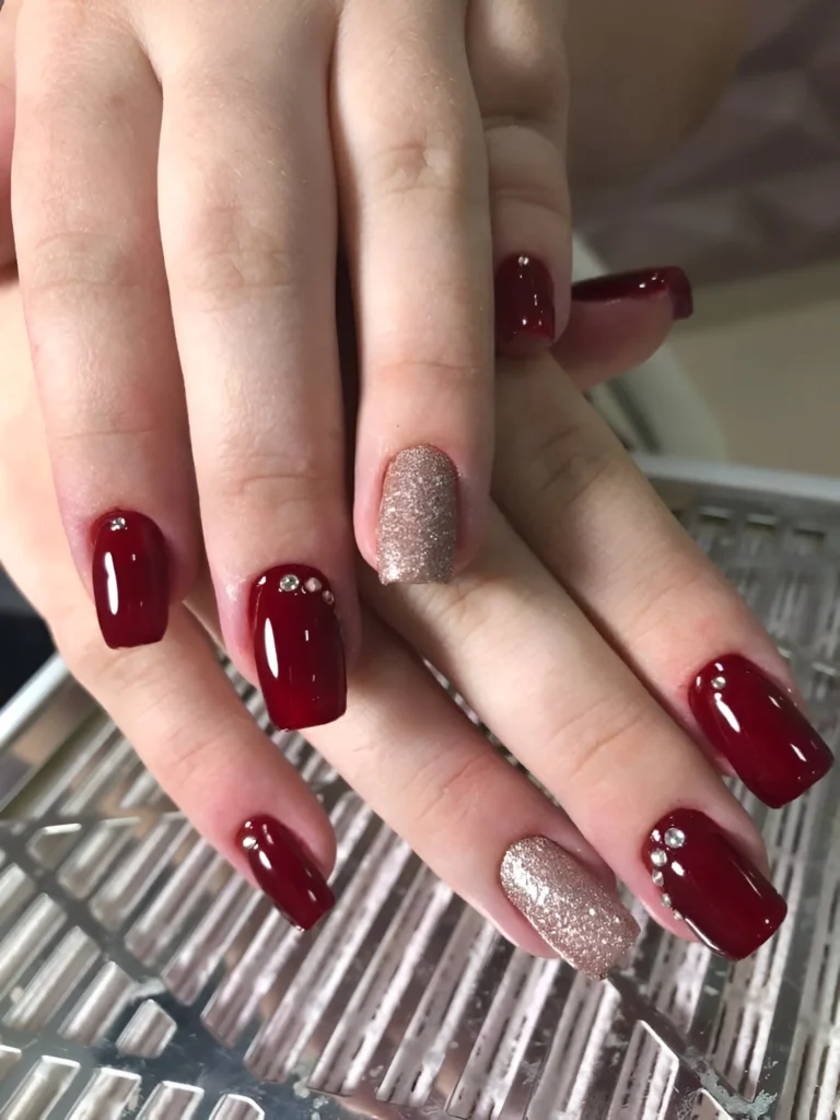 Ruby red nails with rhinestone accents.