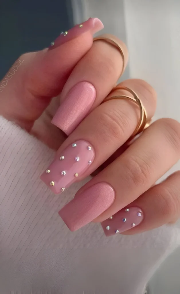 Dusty rose nails with matte and glossy finishes, and iridescent rhinestone accents.