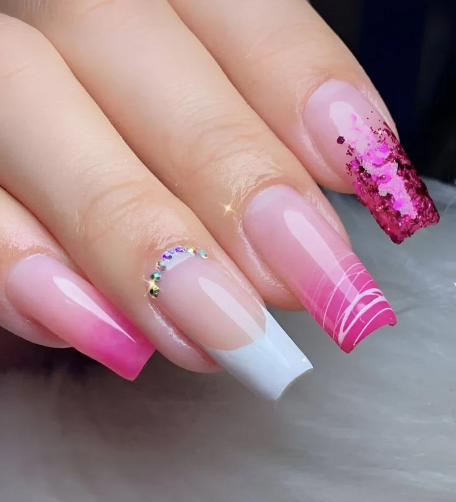 Nails with French tip, pink ombre, abstract design, and pink glitter accents.