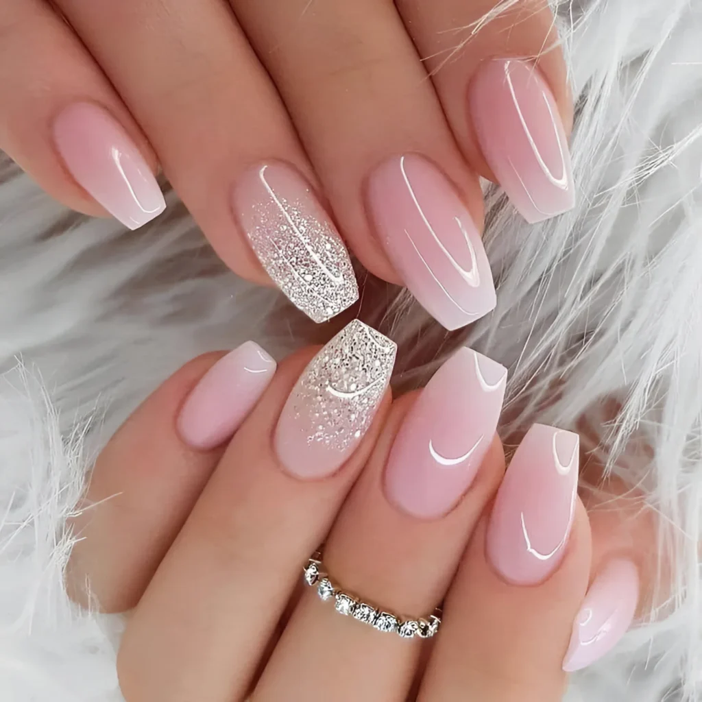 Milky pink coffin nails with pink ombre and silver glitter accents.