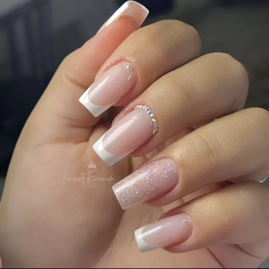 Square French tip nails with glitter and rhinestone accents.