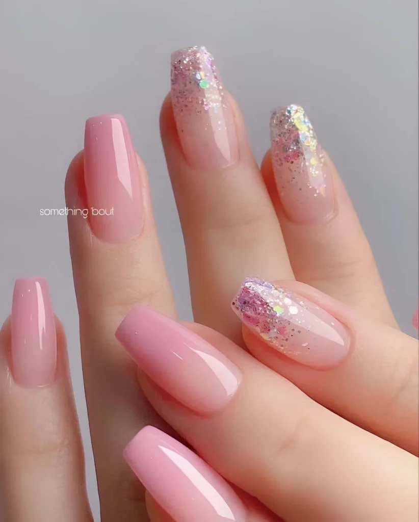 Pink ombre nails with chunky glitter accent nails.