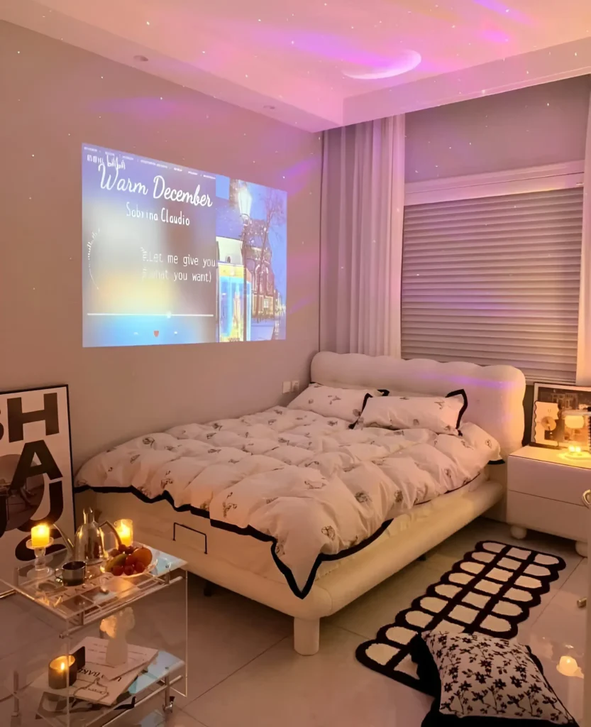 Small bedroom with a projector displaying an image on the wall above the bed, creating a dynamic and customizable focal point. The bed is white with dark trim.