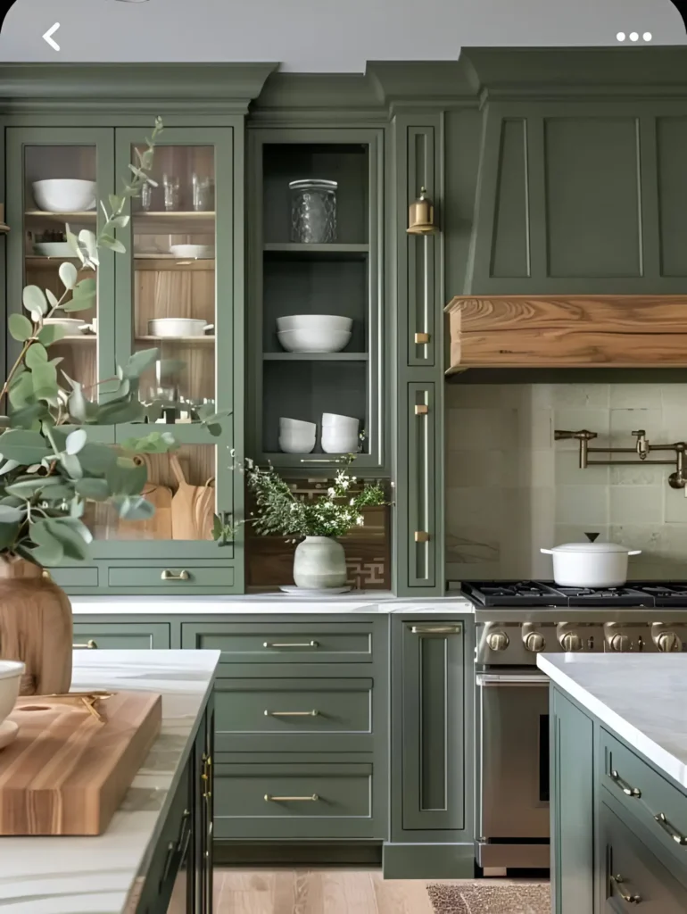 Kitchen with sage green cabinets, light countertops, and wooden accents.